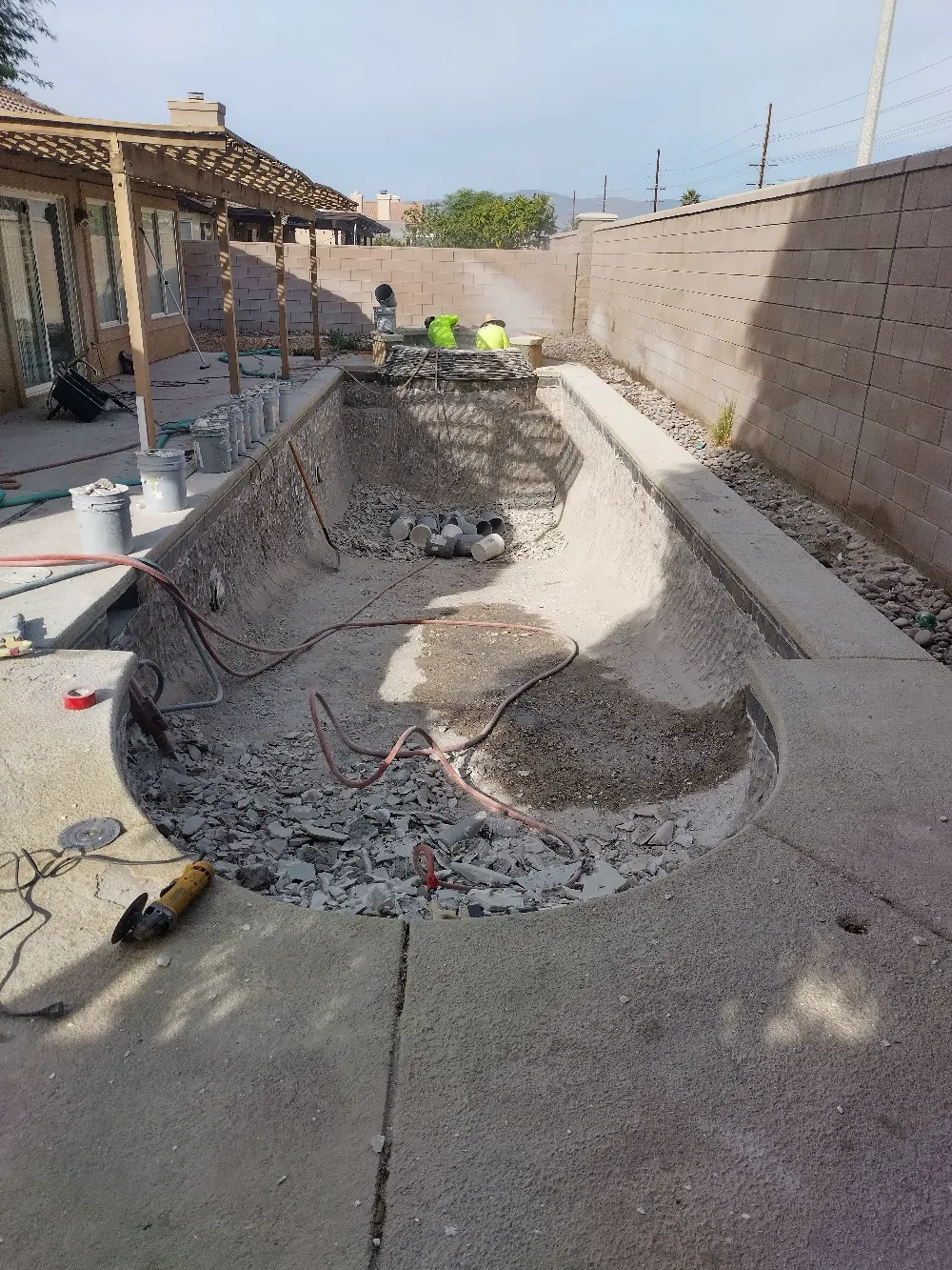 A concrete pool is being built in a backyard